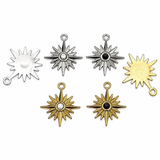 Gold and silver stainless steel starburst charms with black and clear crystal centers on white background