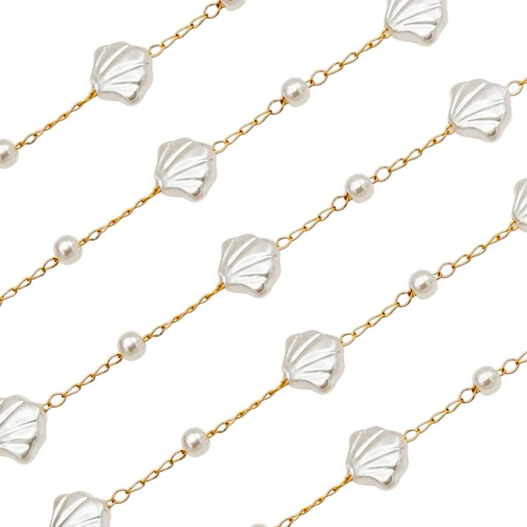 Nautical jewelry chain featuring white pearl beads and detailed seashell links