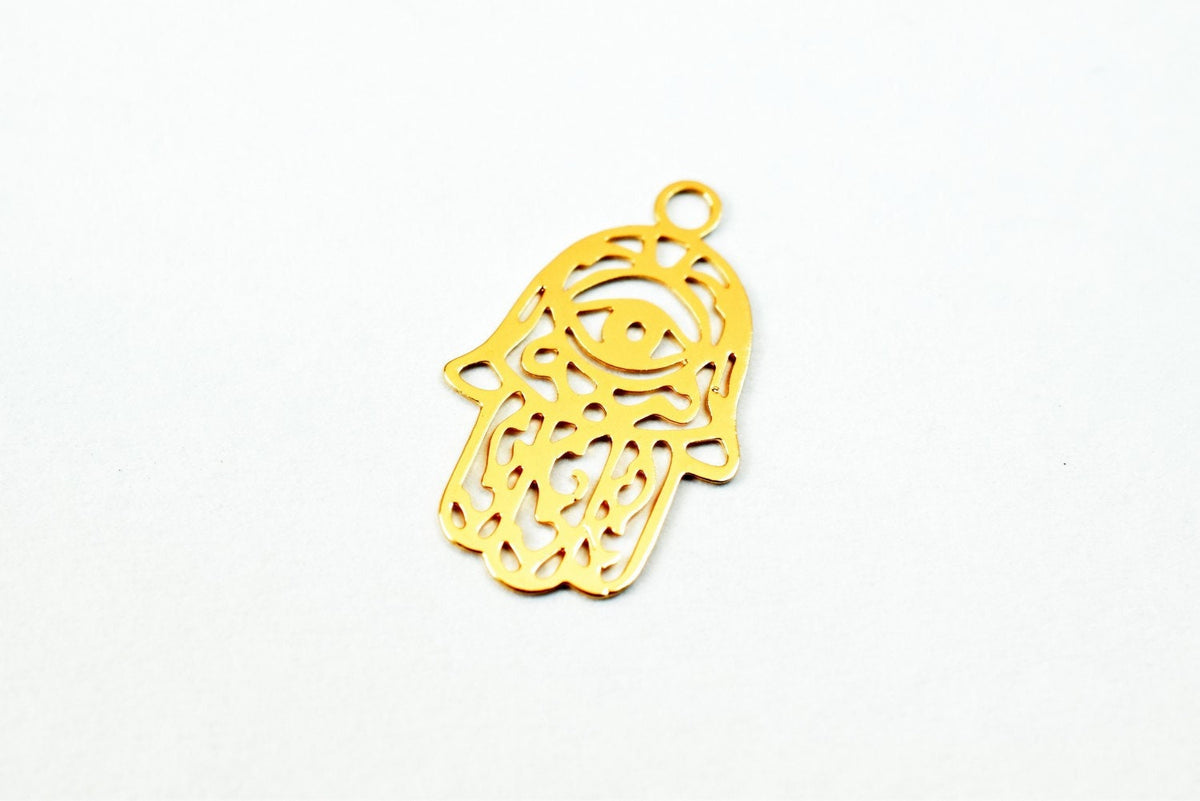 Gold Hamsa hand pendant with eye design on white background.